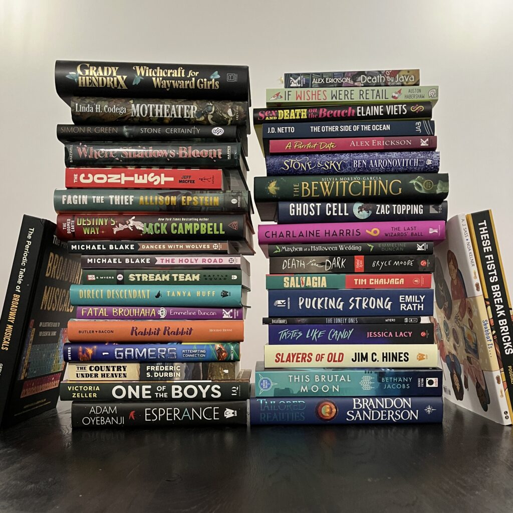Two tall stacks of books showcasing the spines, roughly seventeen books tall. There are thirty-eight books in total; this is approximately two-thirds of the client books we had publish in 2025!